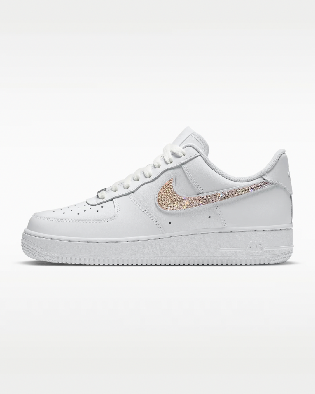 White sneaker with rose gold swoosh logo on a white background
